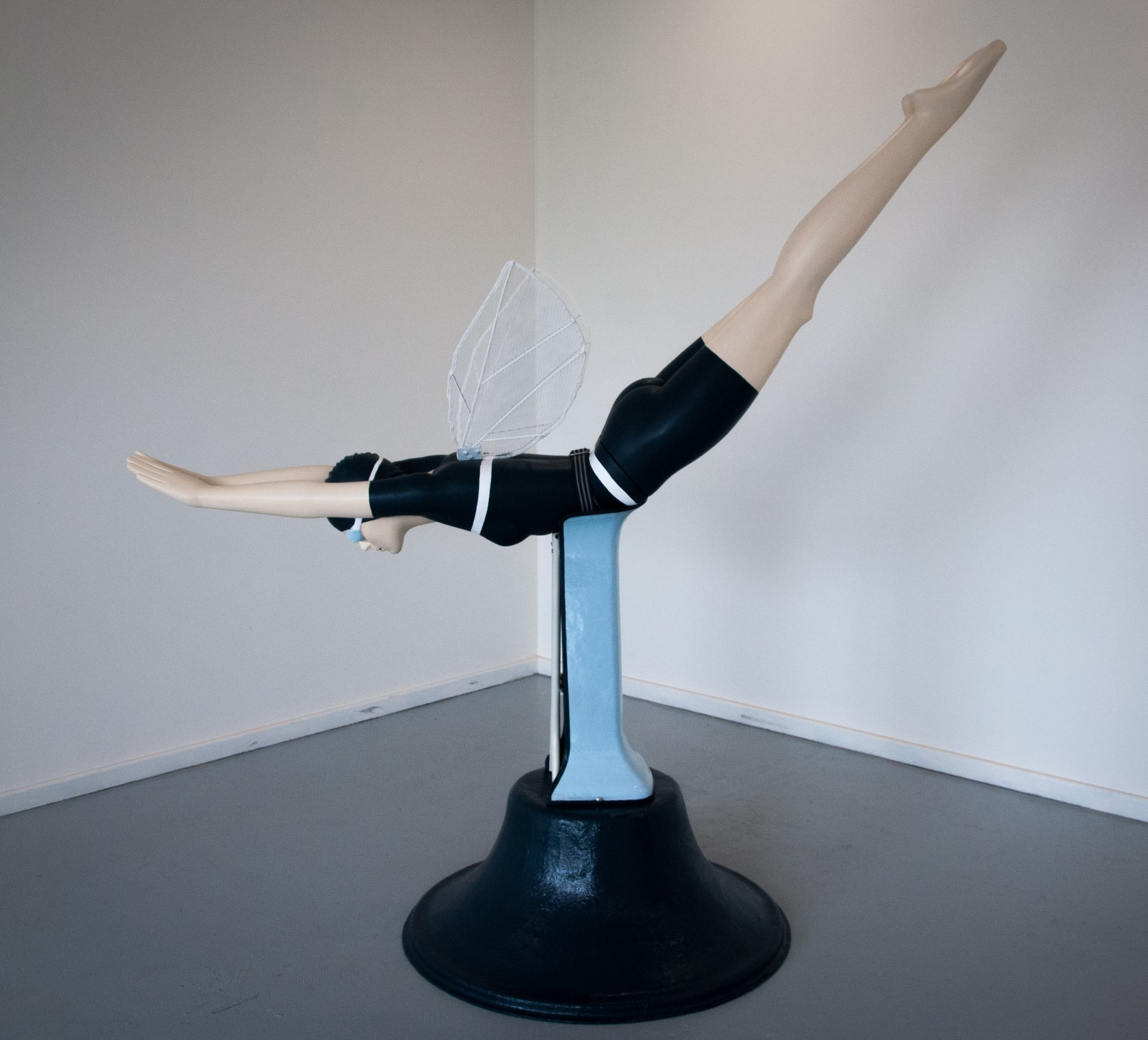 "Emancipation" object sculpture by Libby Bloxham, made of recycled/discarded materials. A life-sized woman in vintage swimwear is in a diving pose, with insect wings added to her back.